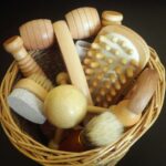 Top view of various wooden massage tools neatly arranged in a woven basket.